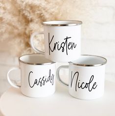 three white coffee mugs with black lettering on them