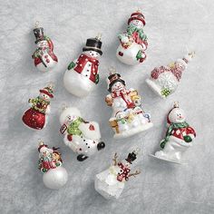 a group of christmas ornaments sitting on top of a snow covered ground next to each other