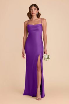 a woman in a purple dress with her legs slited up and holding a bouquet