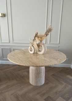 a table with two vases sitting on it's top and an elephant sculpture in the middle