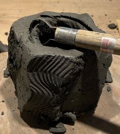 a piece of wood that has been carved into a rock with a hammer sticking out of it