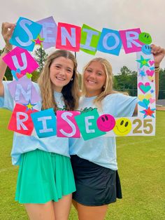 two girls holding up a sign that says senior