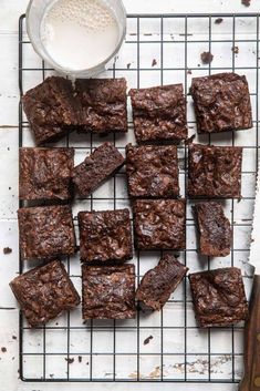 chocolate brownies on a cooling rack next to a bowl of milk