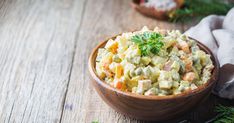 a wooden bowl filled with potato salad on top of a table