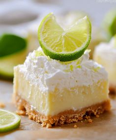 a slice of key lime cheesecake on a cutting board with limes around it