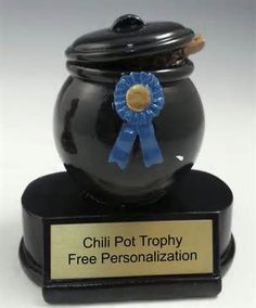 a black pot with a blue ribbon around it and a plaque that says chili pot trophy free personalization