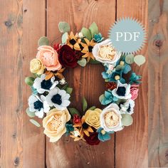 a wreath made out of felt flowers on a wooden background with the word pdf above it