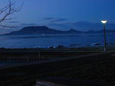 a street light sitting on the side of a road next to a body of water