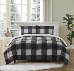 a black and white plaid comforter set on a bed in front of a window