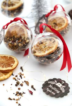 three glass ornaments with orange slices in them