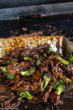 the meat and broccoli dish is ready to be served on the grill with a large spatula