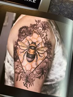 a bee tattoo on the arm and shoulder