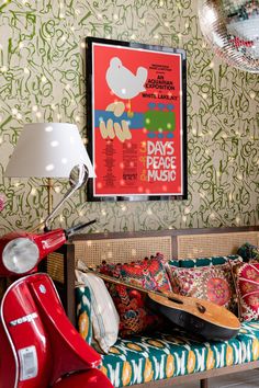 a red scooter is parked in front of a poster on the wall next to a couch