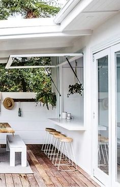 an outdoor dining area with white walls and wood flooring