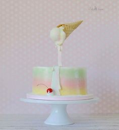 a cake with an ice cream cone sticking out of it's top and a cherry on the side