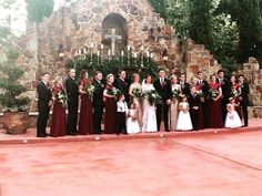 a large group of people standing in front of a stone building with candles on it