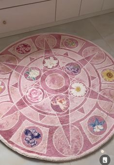 a round rug with flowers on it in a kitchen flooring area next to cabinets and drawers