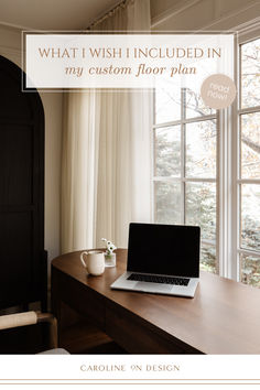 an open laptop computer sitting on top of a wooden desk in front of a window