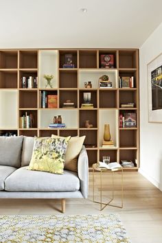 a couch sitting in front of a book shelf filled with books