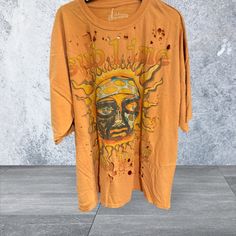 Sublime This Cozy Sublime Distressed Crew Neck T-Shirt In A Blend Of Orange And Yellow Hues Exudes Sunset Vibes. The Large Graphic Design On The Front Features A Stylized Sun Or Face With Radiating Lines, Accented By Small Splatters In A Reddish-Brown Color. The Soft And Comfortable Fabric Makes It Perfect For Casual Wear. Nwt B.4 Stylized Sun, Radiating Lines, Sunset Vibes, Yellow Hues, Crew Neck Tshirt, Tropical Island, Reddish Brown, Orange And Yellow, Brown Color