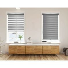 a bathroom with two windows and a wooden cabinet in front of the window that has white blinds on it