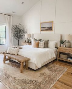 a bed room with a neatly made bed next to a window and a rug on the floor