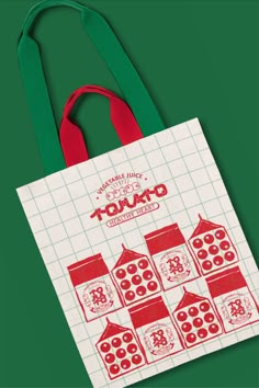 a red and white shopping bag sitting on top of a green surface