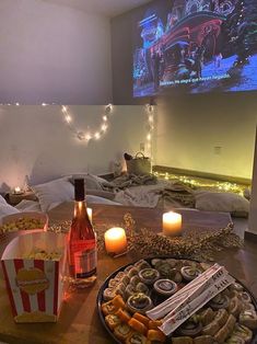 a table topped with food and drinks next to a flat screen tv on top of a wall