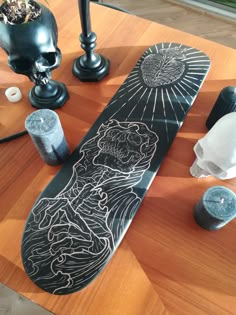 a skateboard sitting on top of a wooden table next to candles and other items