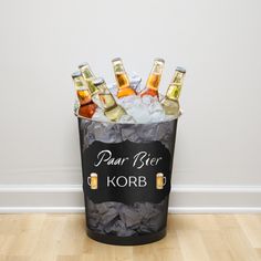 a bucket filled with beer bottles sitting on top of a wooden floor