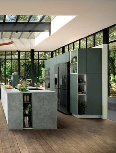 a modern kitchen with wood floors and skylights