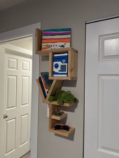 a wooden shelf with books and other items on it next to a door in a room