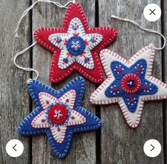 three red, white and blue stars hanging from string on wooden planked surface with strings