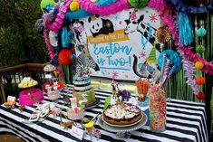 a table topped with cakes and desserts on top of a black and white striped table cloth