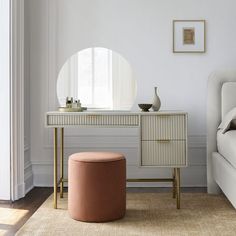 a bedroom with a vanity, mirror and stool in it