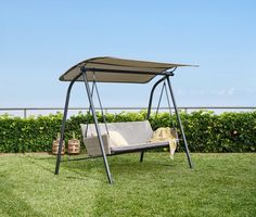 a swing chair with a canopy in the grass