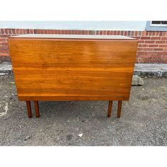 a wooden cabinet sitting in front of a brick wall