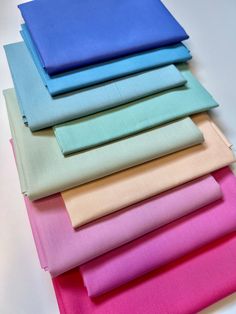 six different colors of fabric laid out on top of each other, including pink, blue, and green