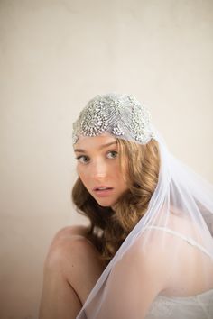 a woman wearing a veil and head piece