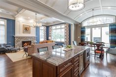 a large open concept living room and dining area with wood flooring, blue walls and ceiling