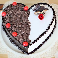 a heart shaped cake with chocolate shavings and cherries