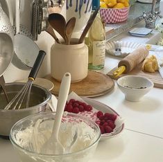 the kitchen counter is cluttered with dishes and utensils, including raspberries