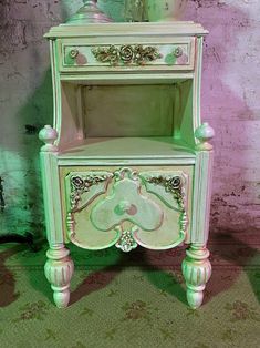 a green and white cabinet sitting on top of a carpeted floor next to a brick wall