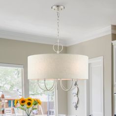 a chandelier hanging from the ceiling in a dining room with sunflowers