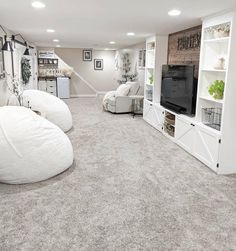 a living room filled with furniture and a flat screen tv on top of a white entertainment center