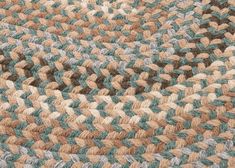 a close up view of a braided rug with blue, brown and white colors