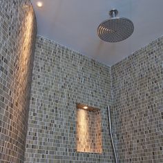 the shower head is mounted on the wall above the bathtub in this tiled bathroom