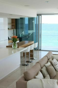 a living room filled with furniture next to an ocean view