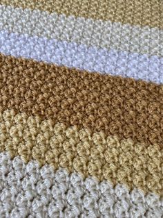 the crocheted blanket is laying on top of each other in different colors and patterns