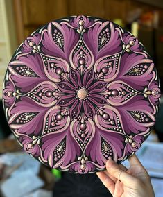 a hand holding up a purple and black plate